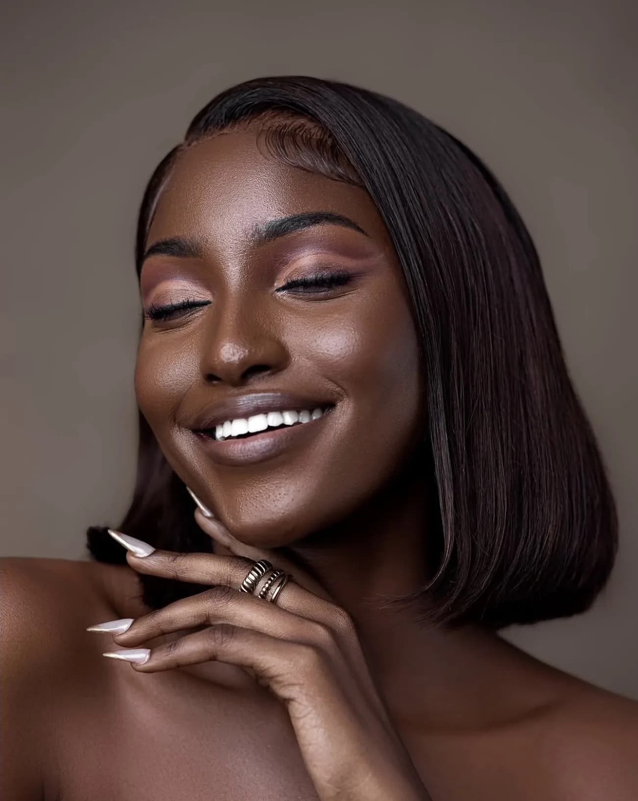 A woman laughing with her eyes closed