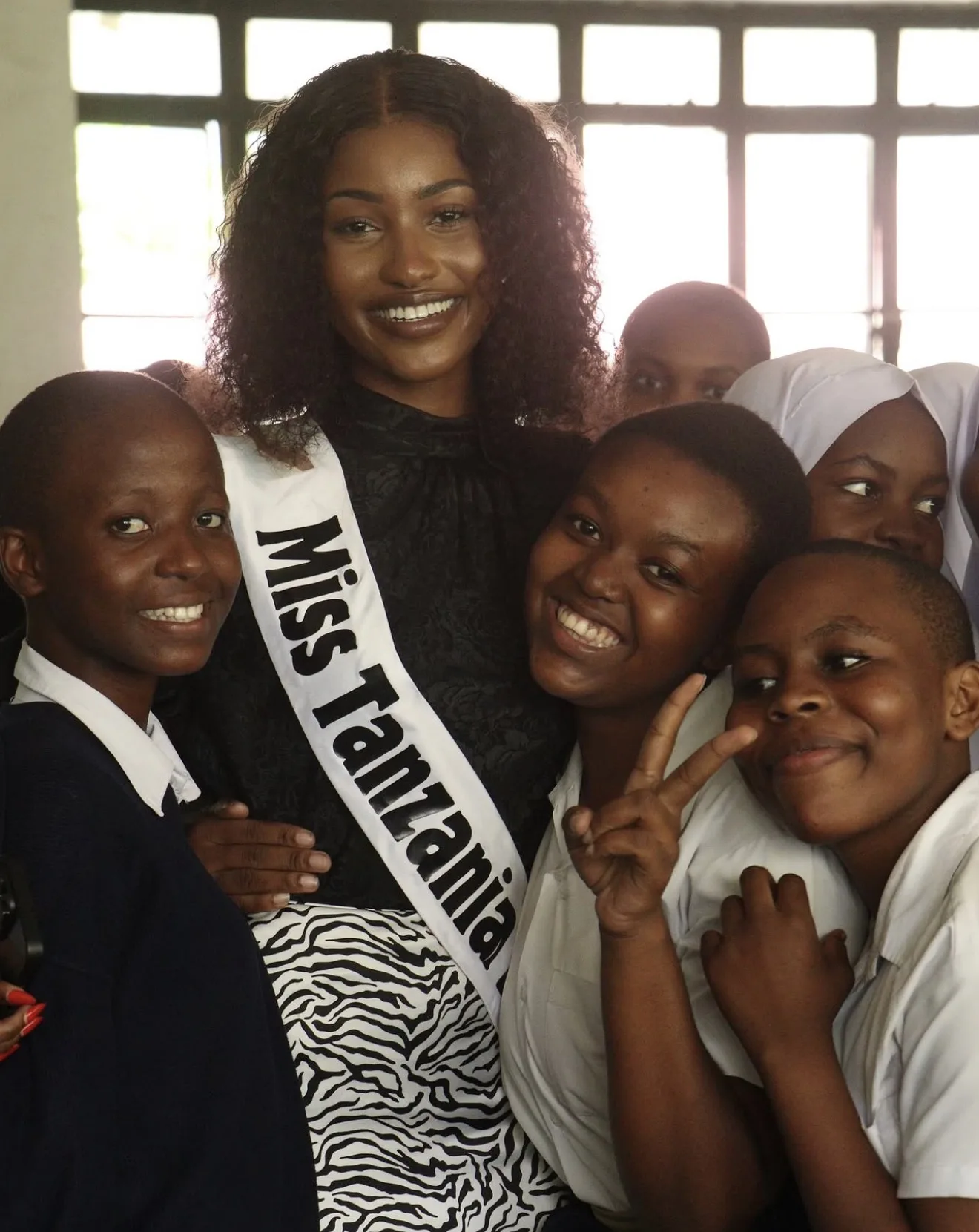 Miss Tanzania with a group of secondary school students in uniform