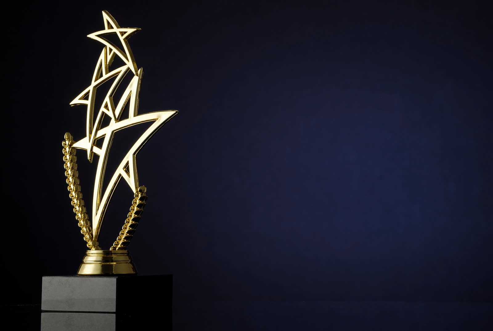 A golden star trophy on a dark background